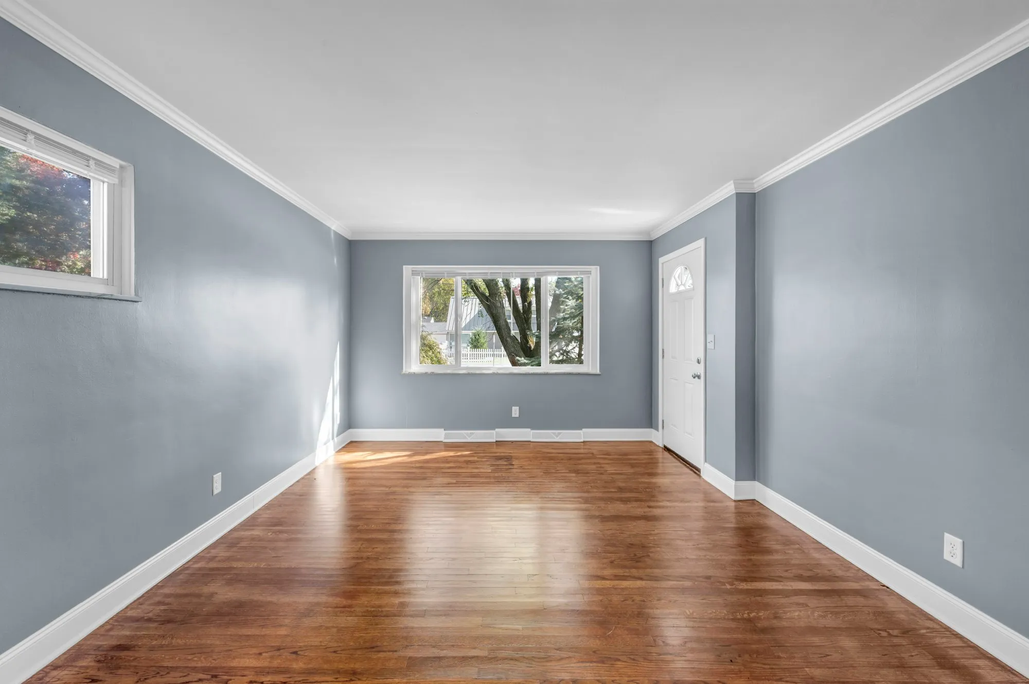 Bright living room with light blue walls and polished hardwood floors