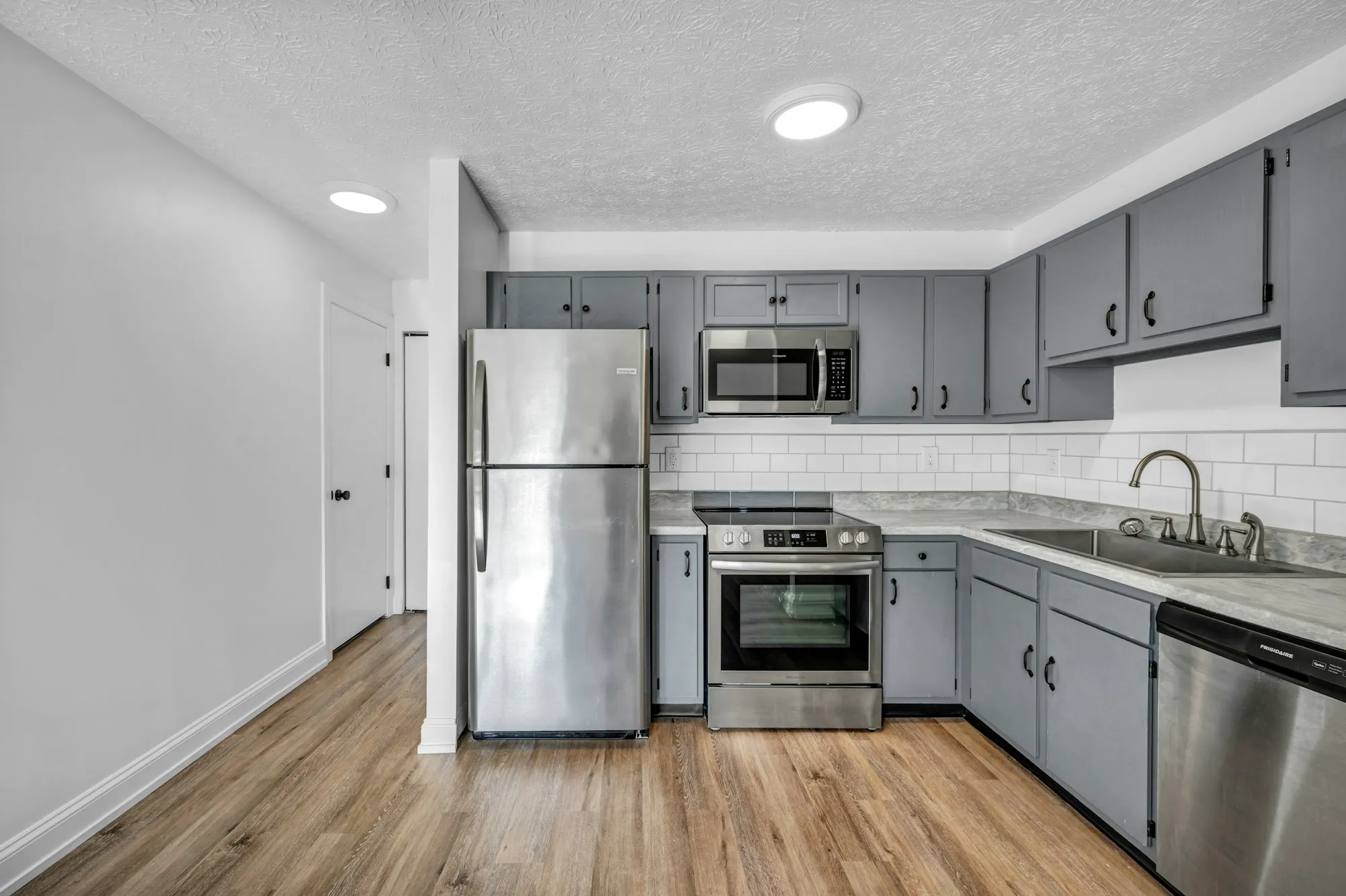 Kitchen with grey cabinets and a white subway tile backsplash
