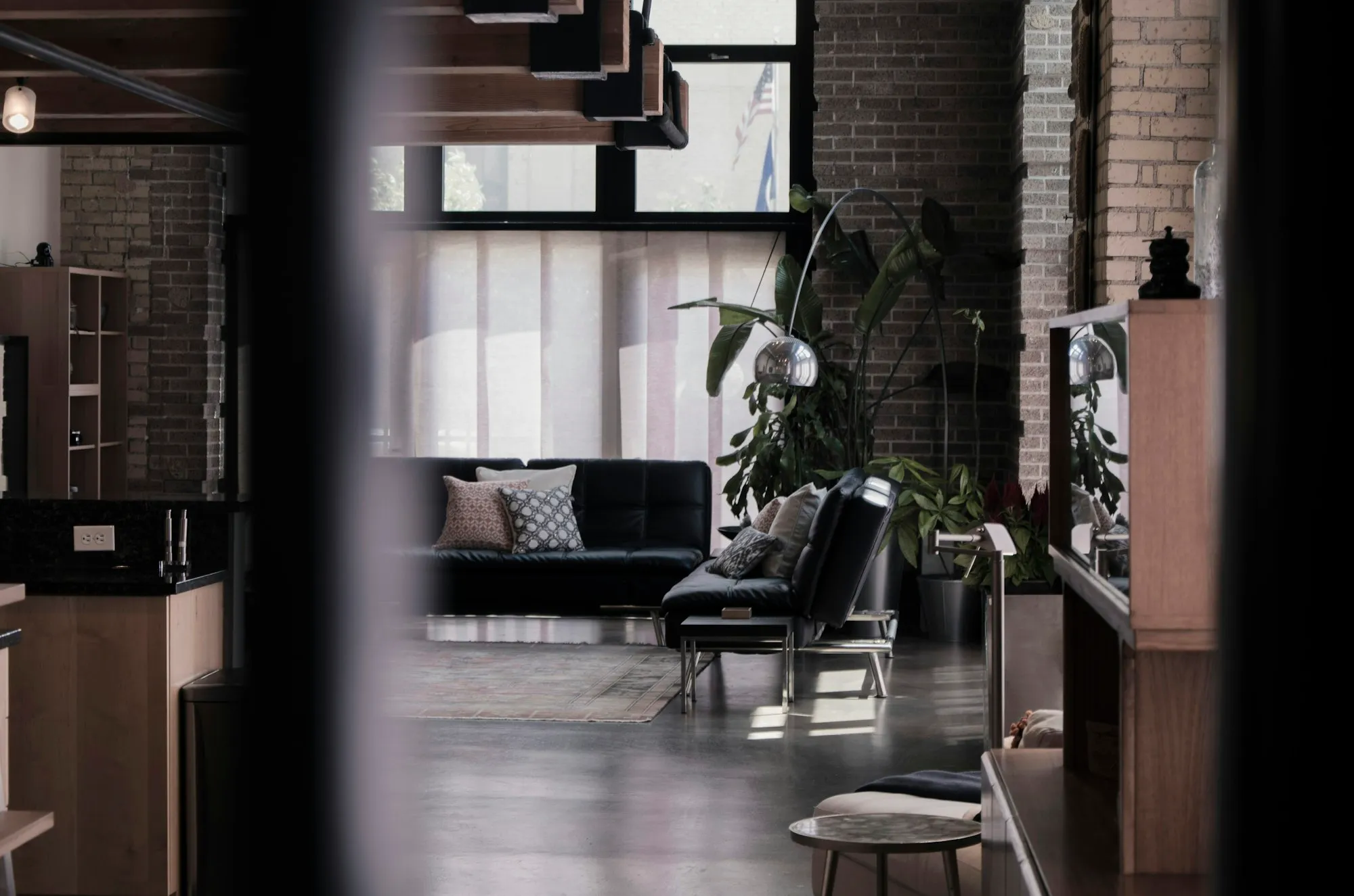 Loft living area with a black leather sofa and throw pillows